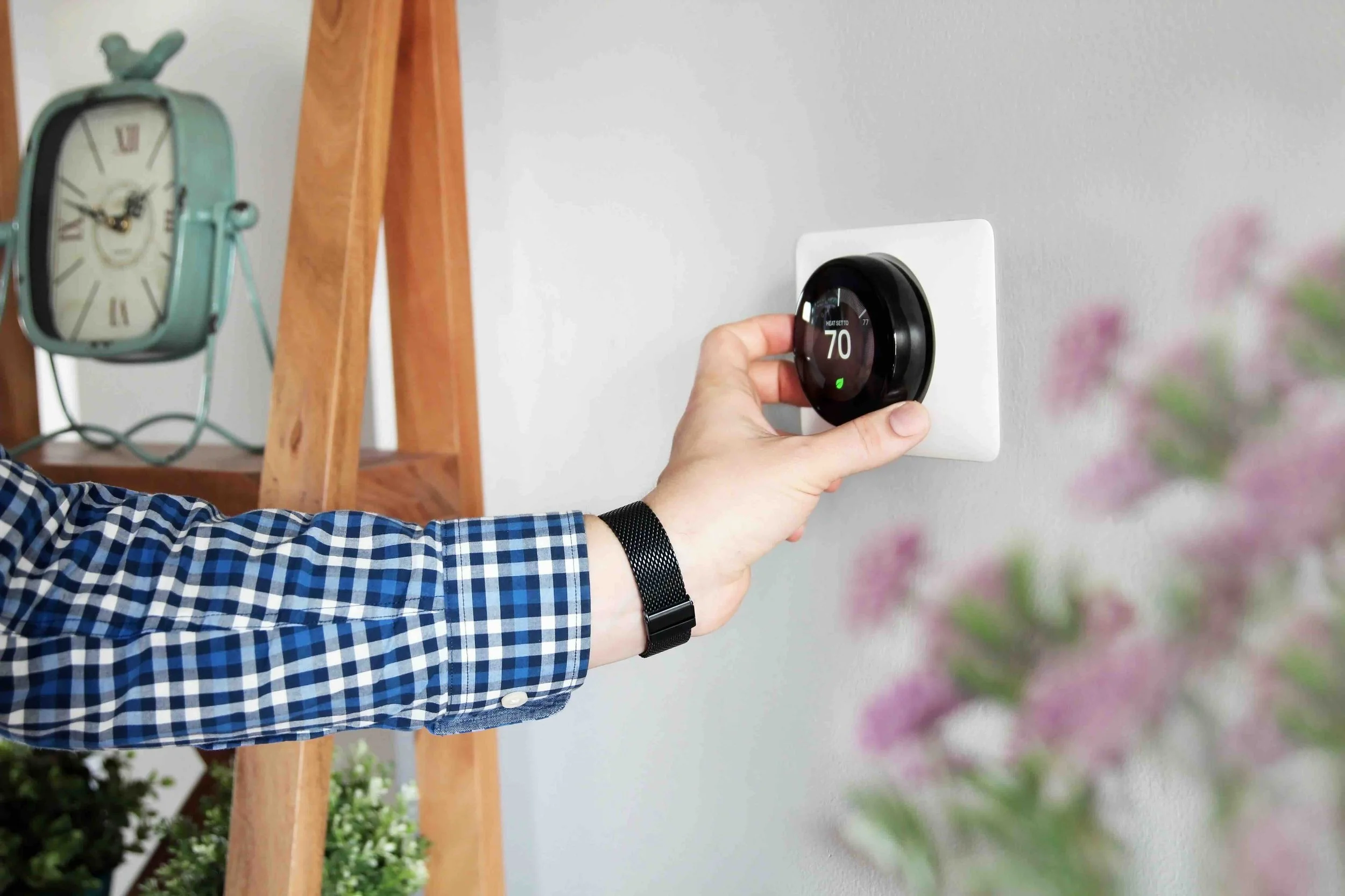person adjusting a thermostat