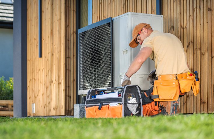tech repairing a heat pump